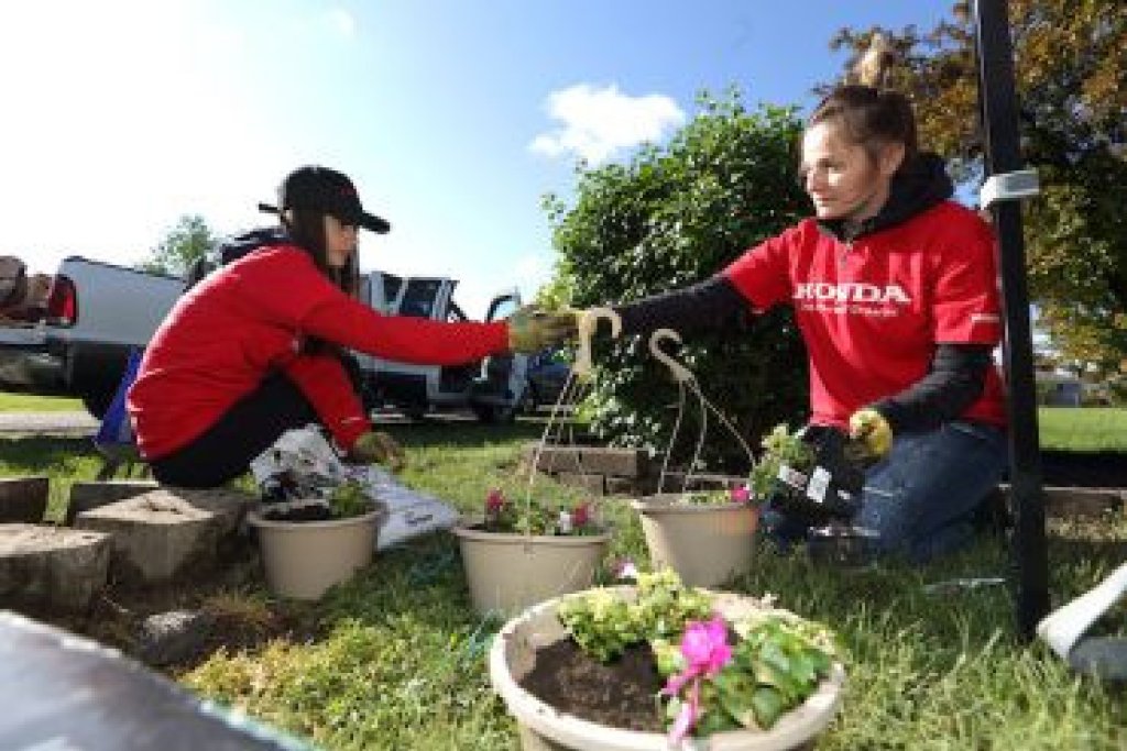 Two people working outside with flower pots.