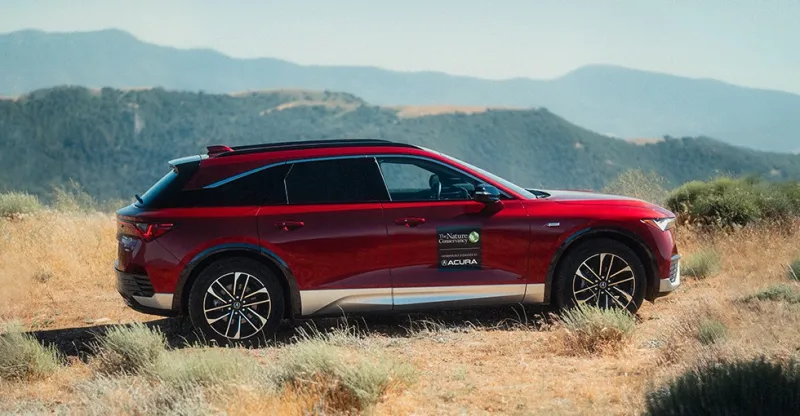 A red Acura SUV with the Nature Conservancy logo on it's side.