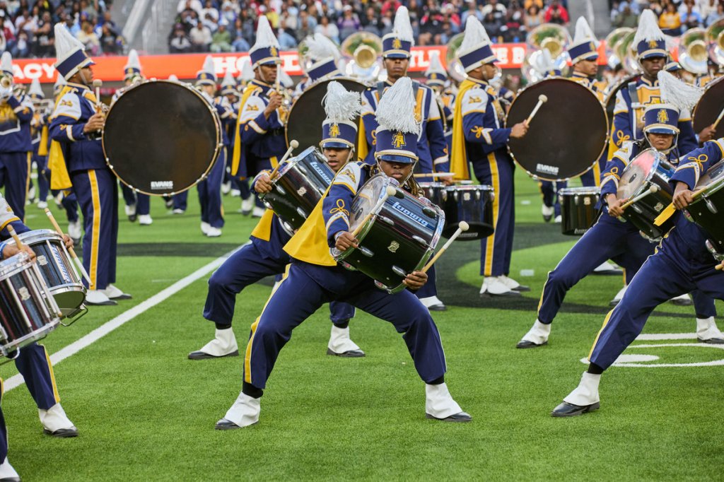 People playing the drums while competing in Honda Battle of the Bands in a stadium.