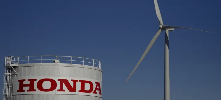 A wind turbine next to a Honda water tower