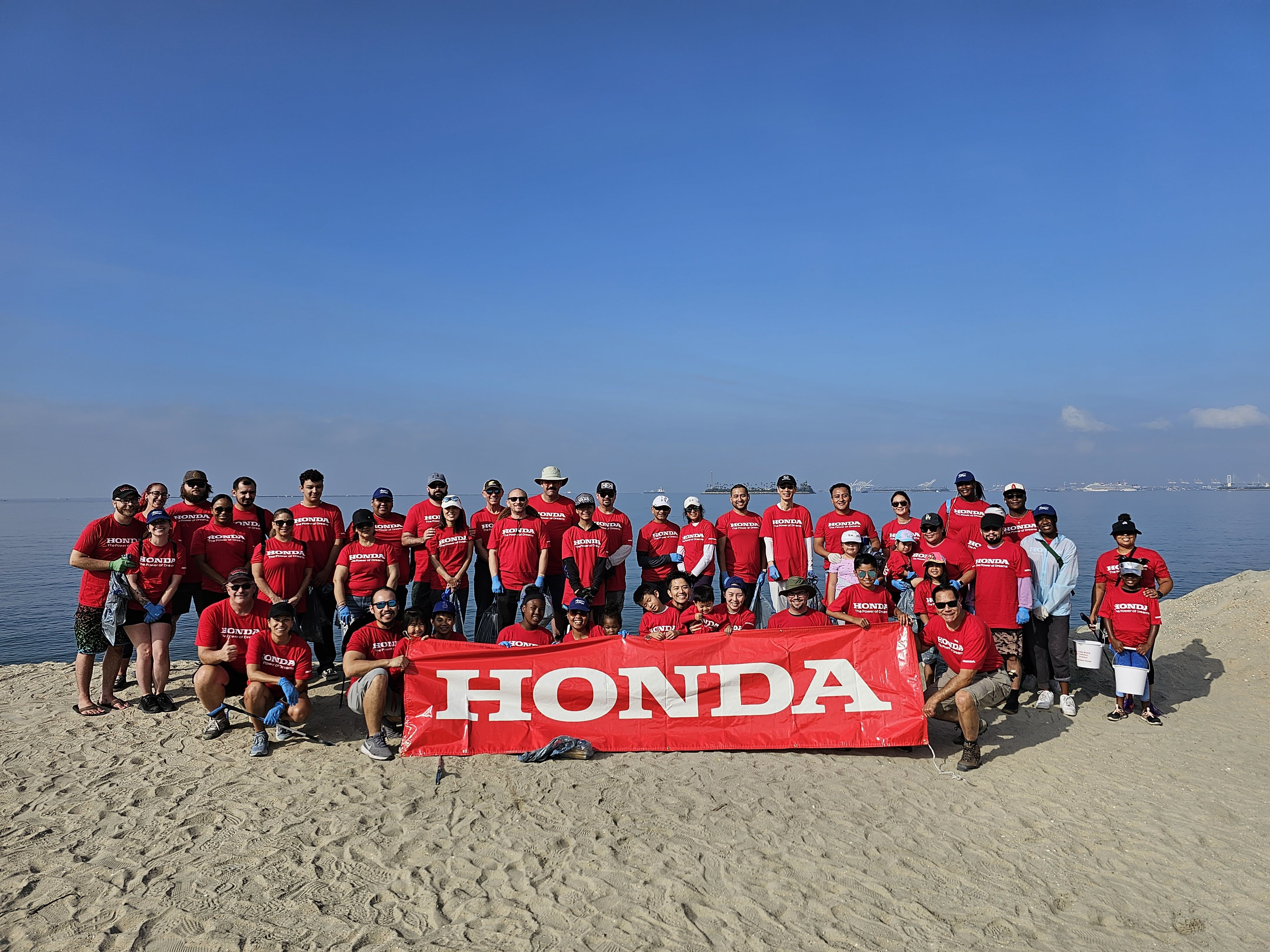 Honda volunteers on a beach showing a Honda banner