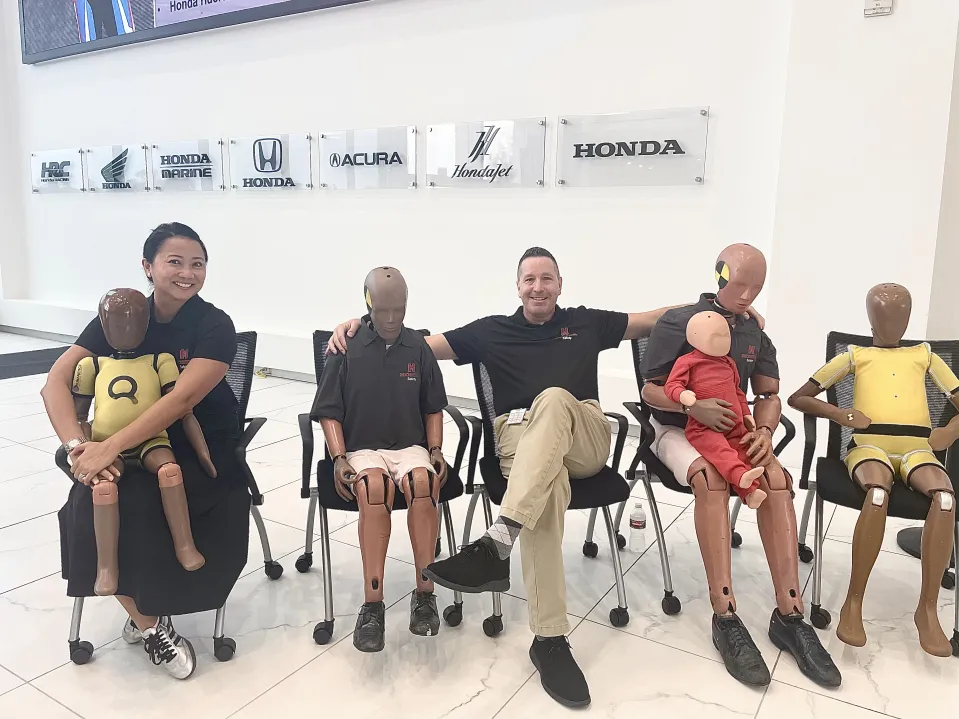 People posing with crash test dummies.